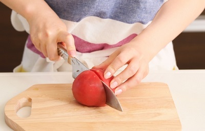 cut tomato with kitchen knife