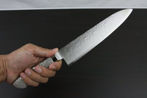 Japanese Chef Knife, Hammer Finish Series, Gyuto chef knife 210mm left-handed, grabbed by a man's hand