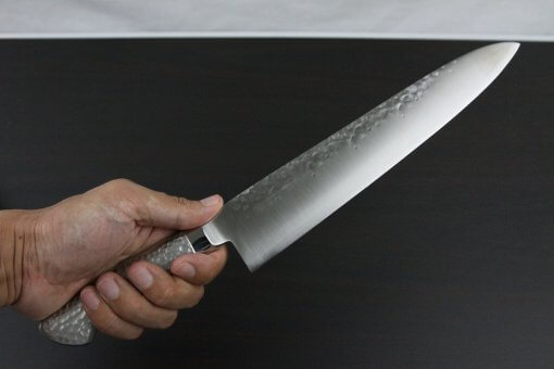 Japanese Chef Knife, Hammer Finish Series, Gyuto chef knife 240mm left-handed, grabbed by a man's hand