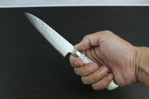 Japanese Chef Knife, Hammer Finish Series, Petit knife 120mm, grabbed by a man's hand