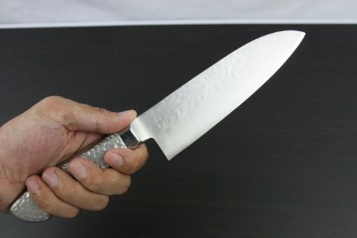 Japanese Chef Knife, Hammer Finish Series, Santoku multi-purpose knife 165mm left-handed, grabbed by a man's hand