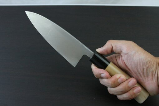 Japanese professional chef knife, Deba fillet knife, steel 150mm, grabbed by a man's hand