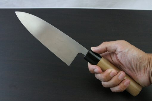 Japanese professional chef knife, Deba fillet knife, steel 180mm, grabbed by a man's hand