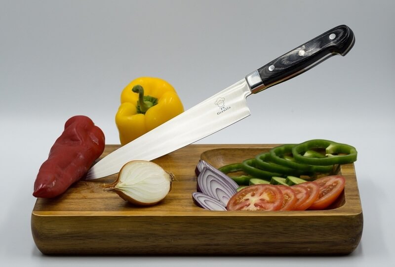 Japanese Chef’s Knives (Gyuto) and Kitchen Knives (Santoku), knife on cutting board with vegetables