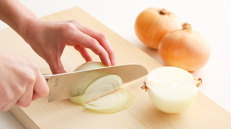 Japanese Chef’s Knives (Gyuto) and Kitchen Knives (Santoku), someone cutting vegetable on a board