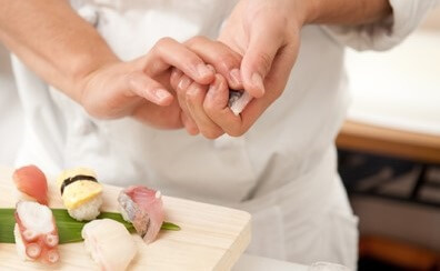 a Sushi chef is making Sushi Nigiri