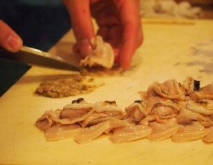 a Sushi chef preparing raw seafood for Sushi