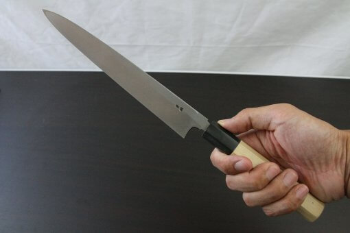 Japanese professional chef knife, Yanagiba sushi knife, steel 240mm, grabbed by a man's hand