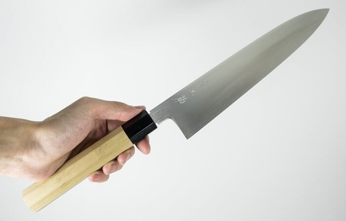reasons to buy Japanese knives, Sushi knife grabbed by a man's hand