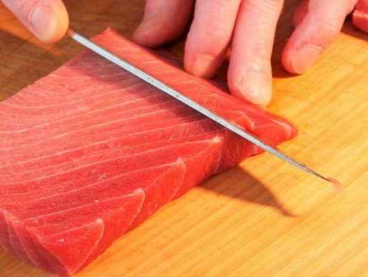 cut tuna sashimi by a sushi knife