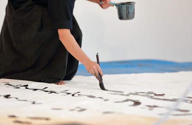 a man is writing Japanese calligraphy writing